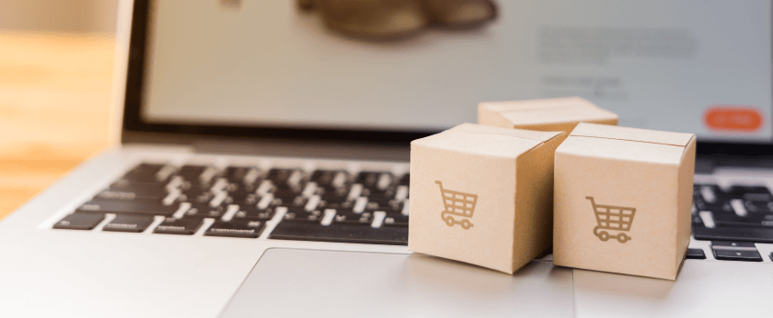 Achats en ligne - Cartons en papier ou colis avec un logo de panier sur un clavier d'ordinateur portable