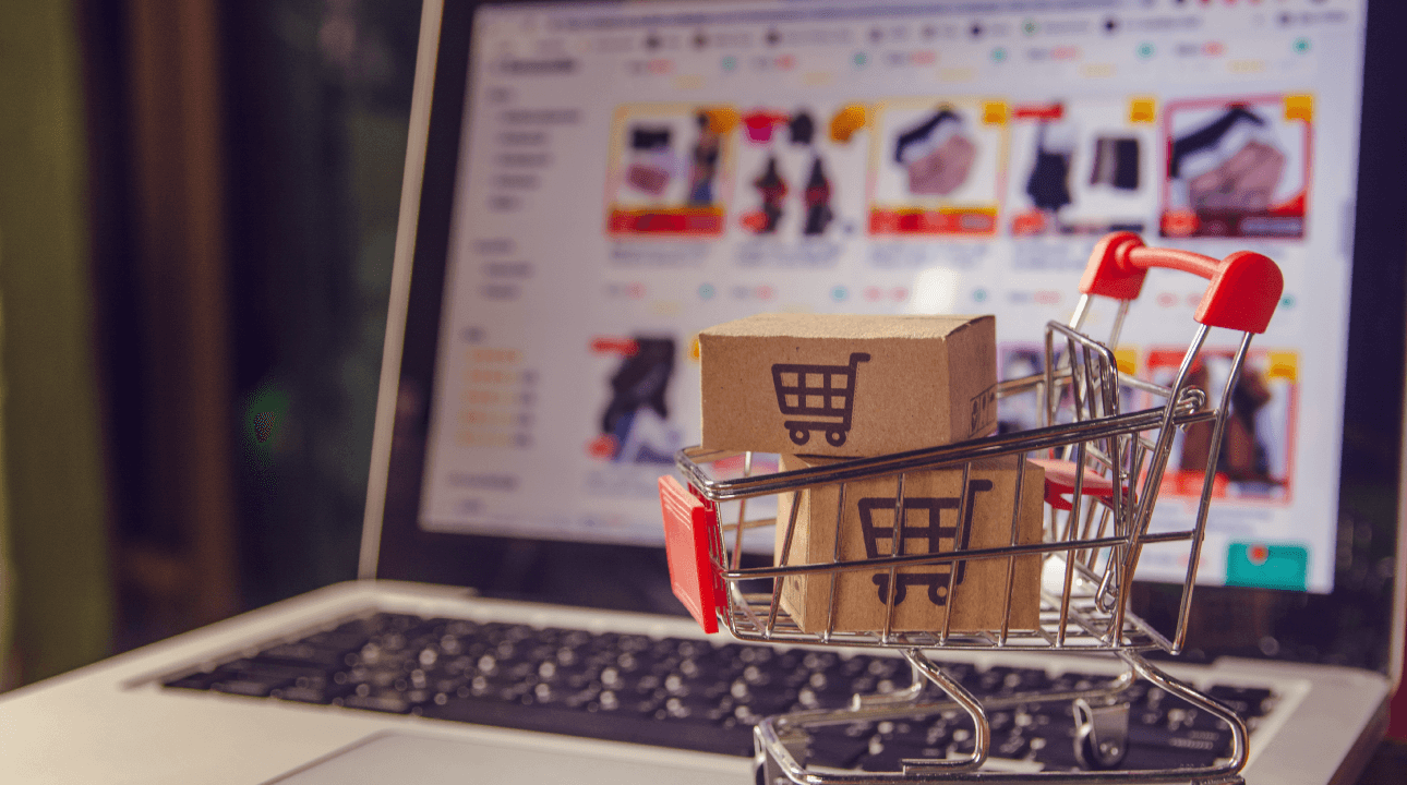 Cartons de colis ou de papier avec un logo de panier dans un chariot sur un clavier d'ordinateur portable